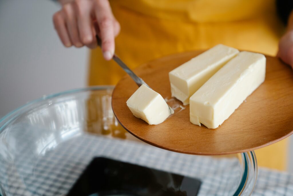 Focused shot of cutting butter for meal preparation, essential cooking ingredient.